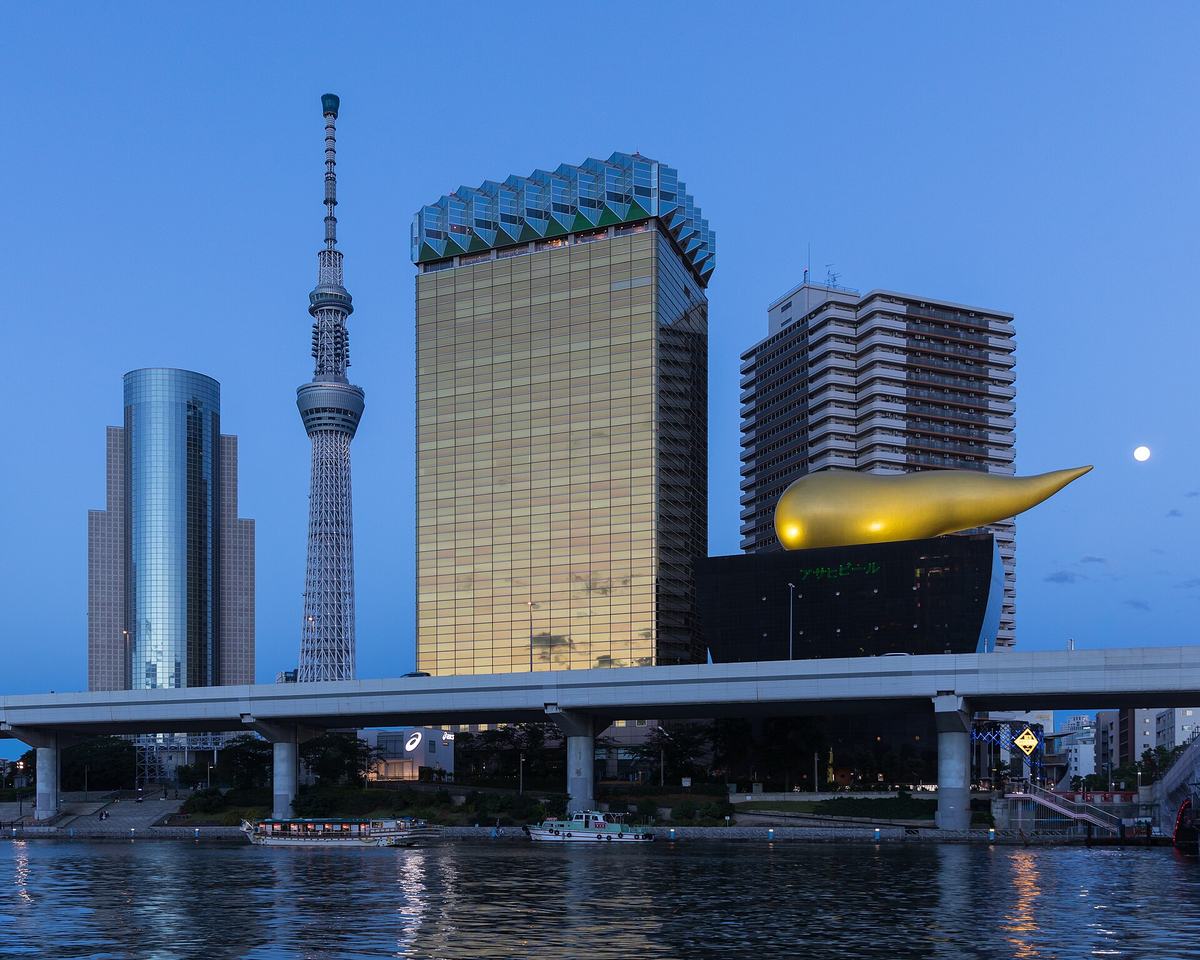 夕暮れのアサヒグループ本社ビルとスーパードライホール。隣に東京スカイツリーが立つ