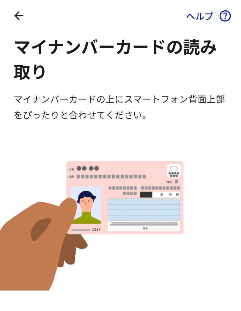 マイナアプリのマイナンバーカード読み取り画面。カードの上にスマートフォン背面上部を合わせる案内