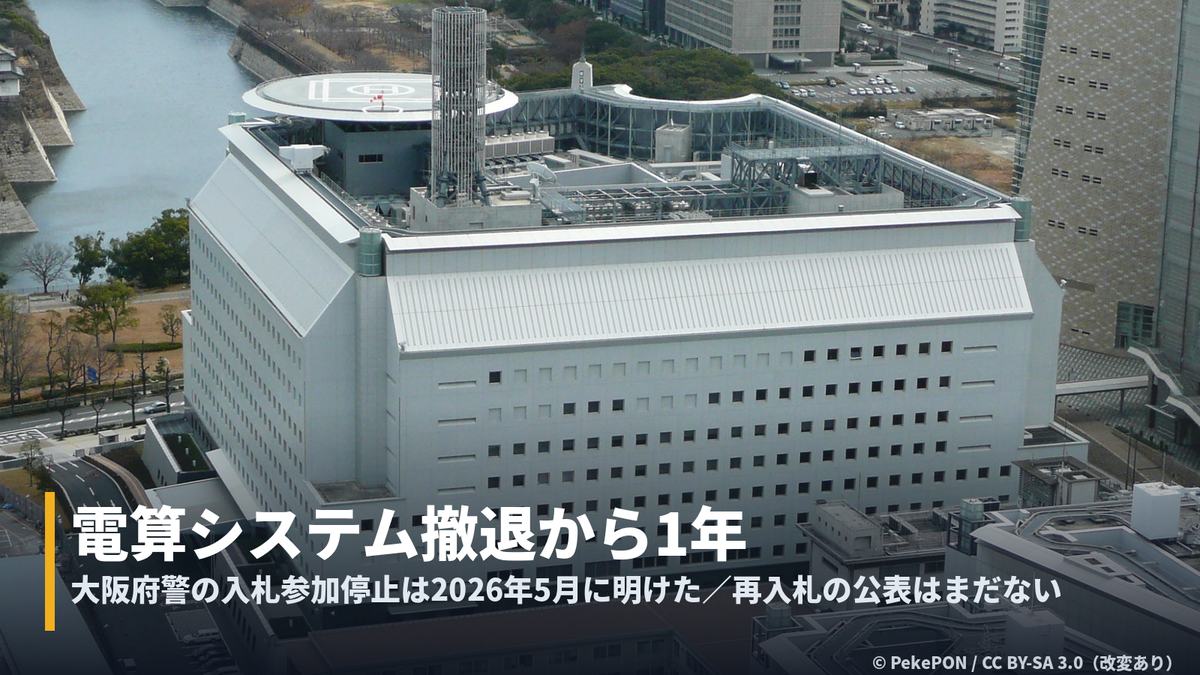 大阪府警察本部の空撮に「電算システム撤退から1年」の字幕帯を重ねたカバー画像